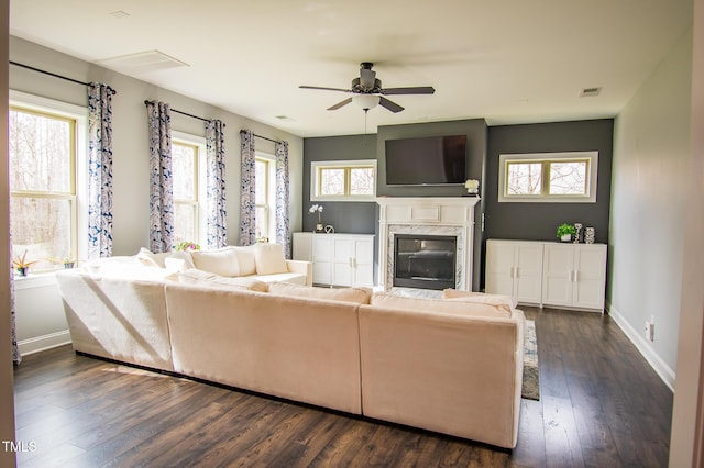 unfurnished living room featuring baseboards, a premium fireplace, visible vents, and dark wood-style flooring