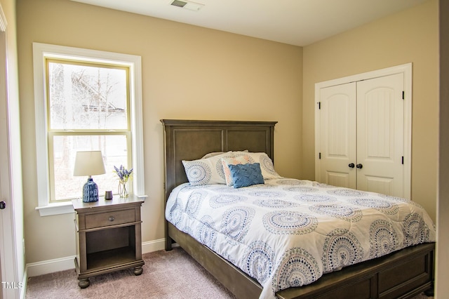 carpeted bedroom featuring visible vents, baseboards, and a closet