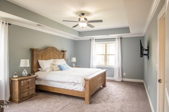 bedroom with light colored carpet, visible vents, baseboards, a raised ceiling, and crown molding