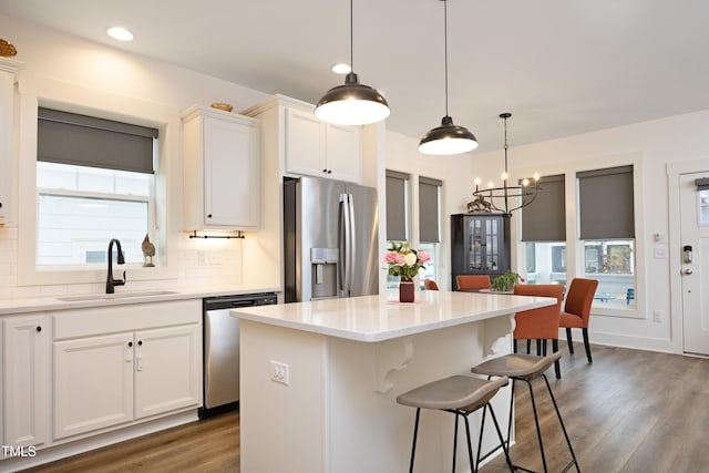 kitchen featuring sink, a kitchen island, white cabinets, and appliances with stainless steel finishes