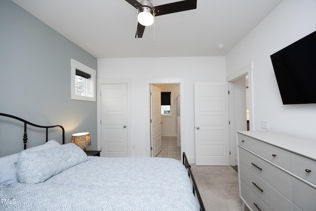 carpeted bedroom featuring connected bathroom and ceiling fan