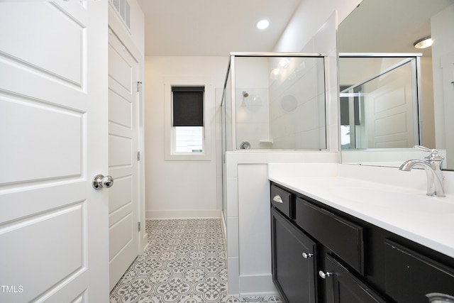 bathroom with vanity, a shower with shower door, and tile patterned floors