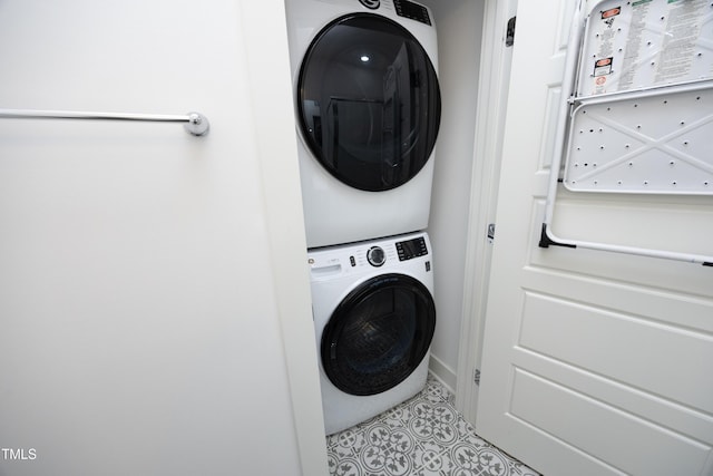 washroom with stacked washer / drying machine and light tile patterned floors