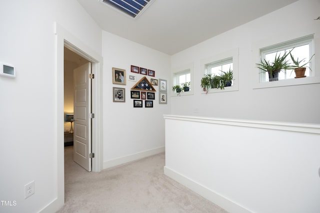 hallway featuring light colored carpet