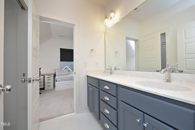 bathroom with vaulted ceiling, vanity, and tile patterned flooring