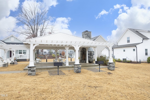 rear view of property featuring a gazebo, a lawn, and a pergola