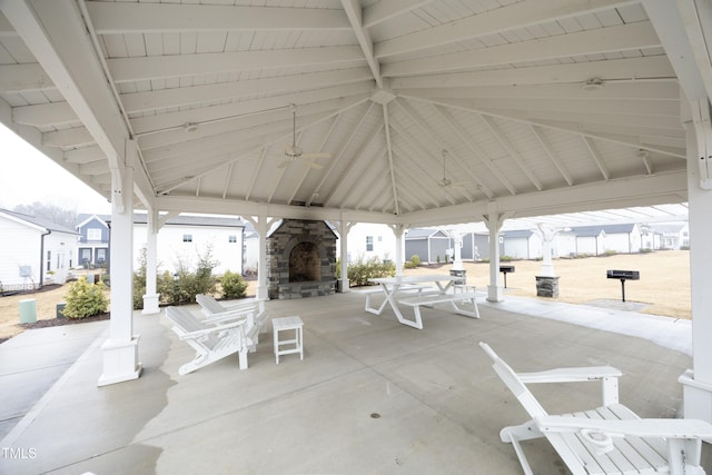 view of patio with a gazebo, ceiling fan, and an outdoor stone fireplace