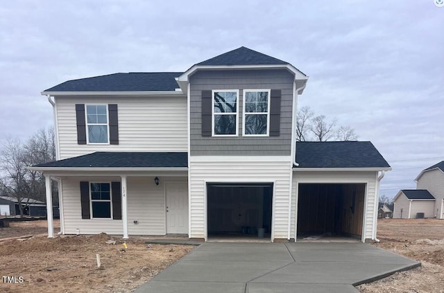 view of property with a garage and a porch