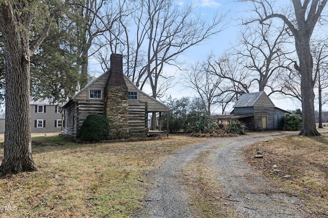 view of side of home featuring an outbuilding
