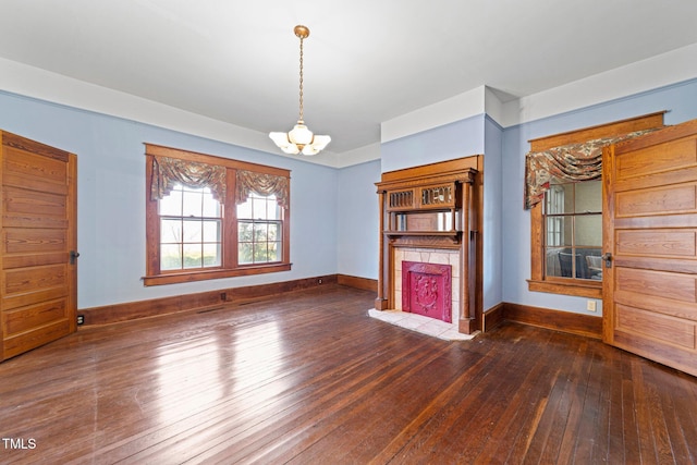 unfurnished living room featuring a tiled fireplace and dark hardwood / wood-style flooring