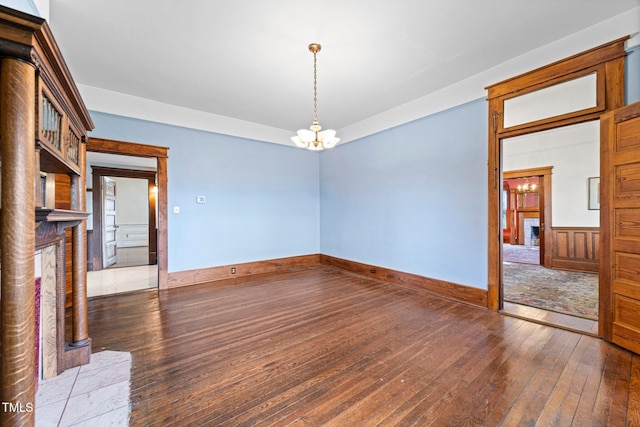 unfurnished room featuring dark hardwood / wood-style flooring and a notable chandelier