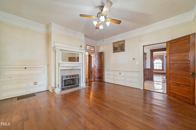 unfurnished living room with ceiling fan, wood-type flooring, and a high end fireplace
