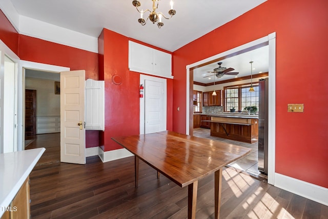 unfurnished dining area featuring ceiling fan with notable chandelier and dark hardwood / wood-style floors