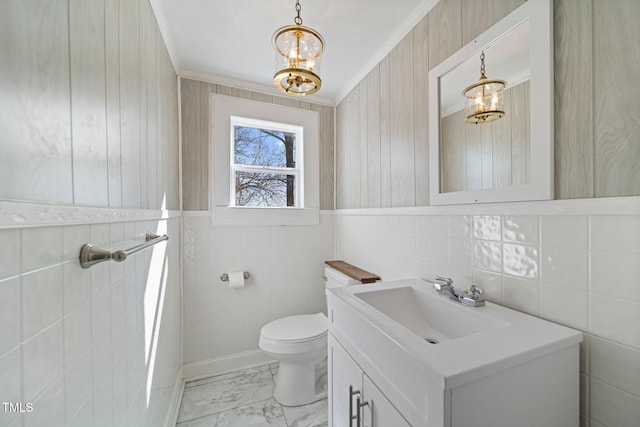 bathroom featuring tile walls, a chandelier, vanity, ornamental molding, and toilet