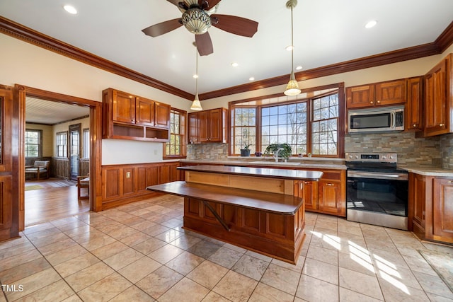 kitchen with light tile patterned flooring, hanging light fixtures, a kitchen island, stainless steel appliances, and backsplash