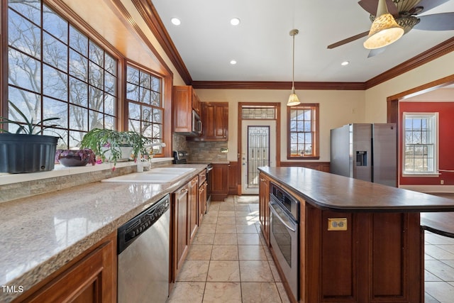 kitchen featuring a kitchen island, decorative light fixtures, tasteful backsplash, ornamental molding, and stainless steel appliances