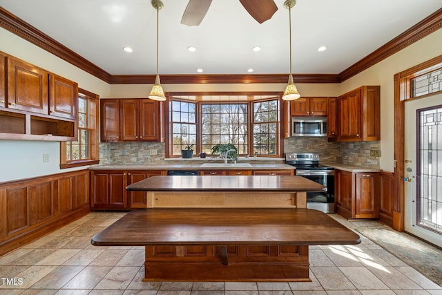 kitchen with stainless steel appliances, a center island, sink, and decorative light fixtures