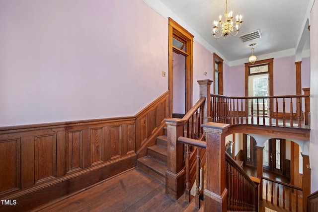 stairway featuring wood-type flooring and a chandelier