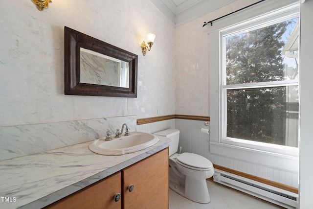 bathroom with tile patterned floors, toilet, baseboard heating, ornamental molding, and vanity