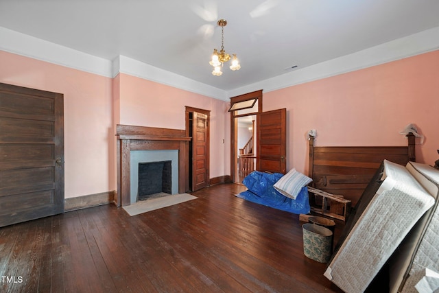 bedroom with dark hardwood / wood-style floors and a chandelier