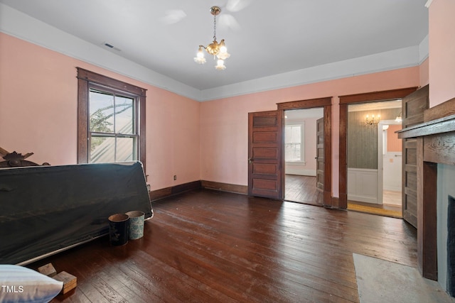 interior space featuring dark wood-type flooring, a fireplace, and a chandelier