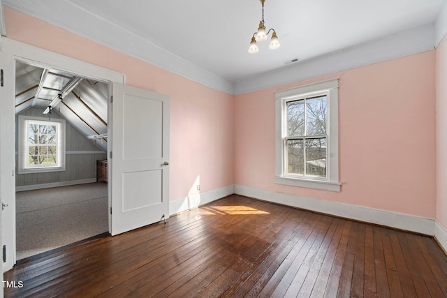 additional living space featuring hardwood / wood-style flooring and an inviting chandelier