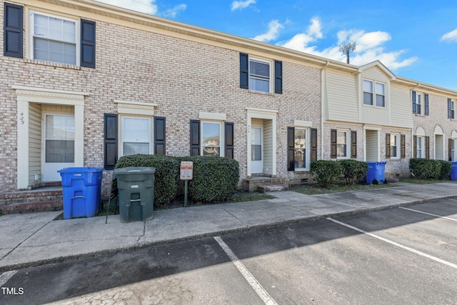 townhome / multi-family property with uncovered parking and brick siding