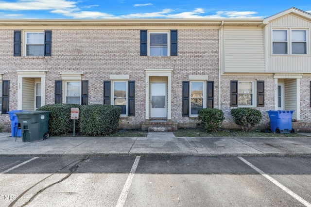 multi unit property featuring brick siding and uncovered parking