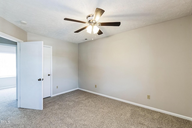 spare room featuring visible vents, baseboards, ceiling fan, a textured ceiling, and carpet flooring