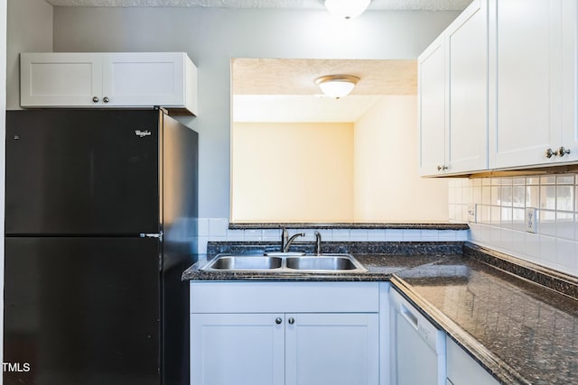 kitchen featuring a sink, freestanding refrigerator, white cabinets, white dishwasher, and decorative backsplash