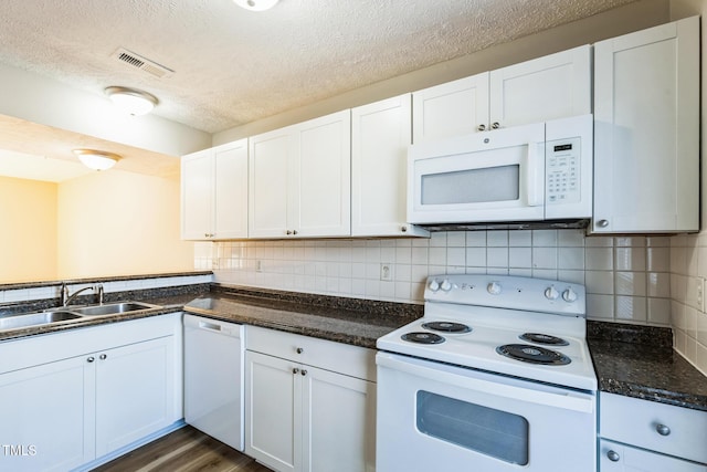 kitchen with visible vents, decorative backsplash, white cabinets, white appliances, and a sink