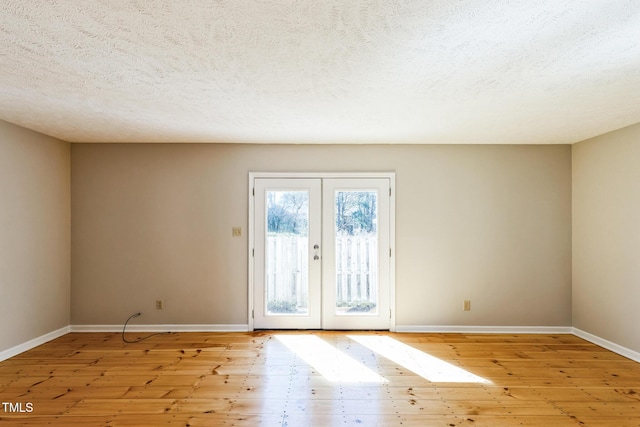 interior space with light wood finished floors, french doors, and baseboards