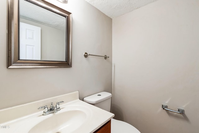 bathroom featuring toilet, vanity, and a textured ceiling