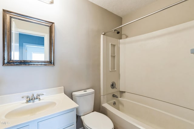 bathroom featuring vanity, bathing tub / shower combination, toilet, and a textured ceiling