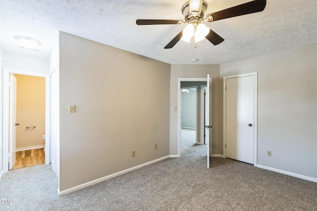 unfurnished bedroom featuring baseboards, carpet floors, and a textured ceiling