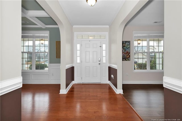 foyer entrance with crown molding and dark wood-type flooring