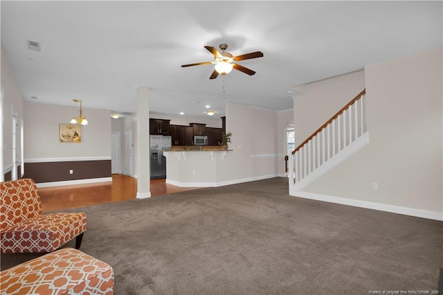 unfurnished living room with ceiling fan and dark colored carpet