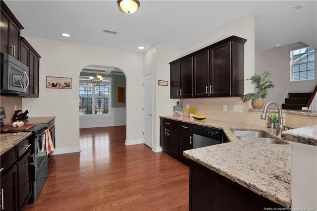 kitchen with light stone counters, sink, stainless steel appliances, and a healthy amount of sunlight