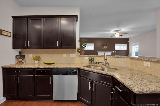 kitchen with sink, dark brown cabinets, stainless steel dishwasher, kitchen peninsula, and backsplash