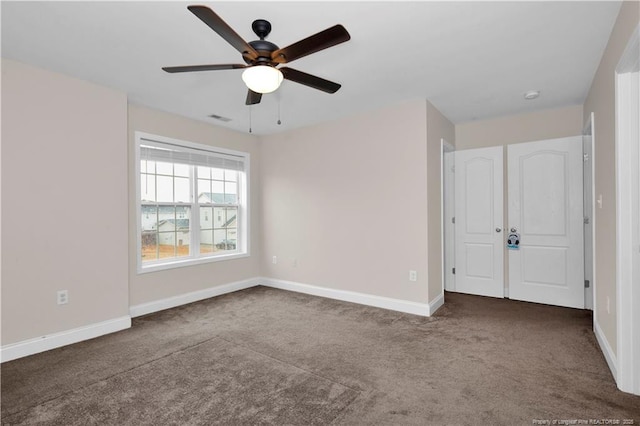 unfurnished bedroom with ceiling fan and dark carpet