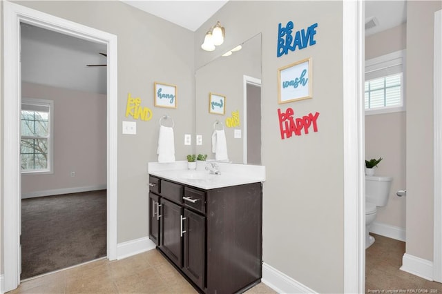 bathroom with vanity, tile patterned floors, toilet, and a healthy amount of sunlight