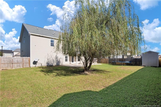 view of yard featuring a trampoline, a storage shed, and a patio area