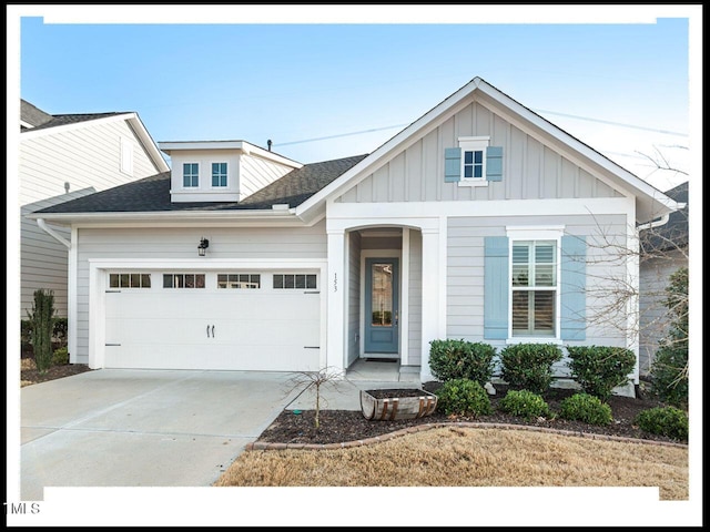 view of front of home with driveway, roof with shingles, a garage, and board and batten siding