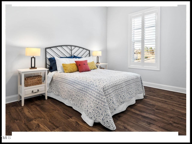 bedroom with dark wood finished floors and baseboards