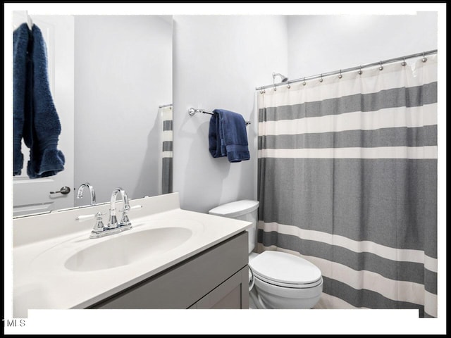 full bathroom with vanity, a shower with shower curtain, and toilet