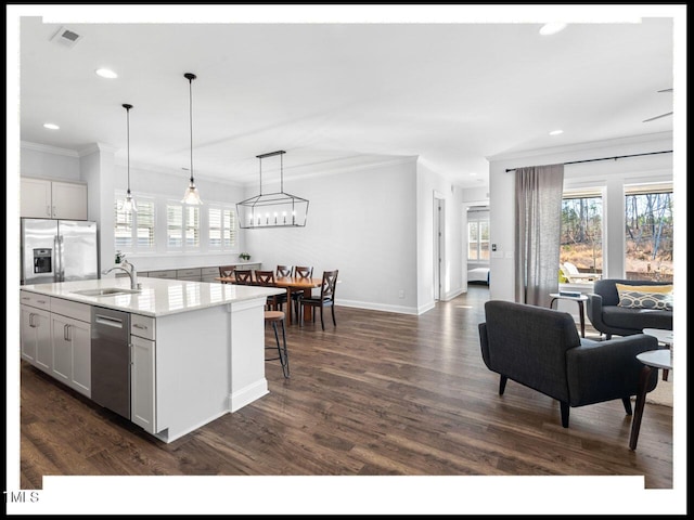 kitchen featuring a sink, stainless steel appliances, visible vents, and ornamental molding