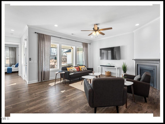 living room featuring a ceiling fan, wood finished floors, a fireplace, crown molding, and baseboards