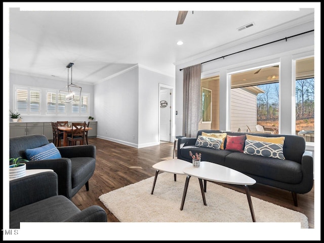 living room with visible vents, plenty of natural light, baseboards, and wood finished floors