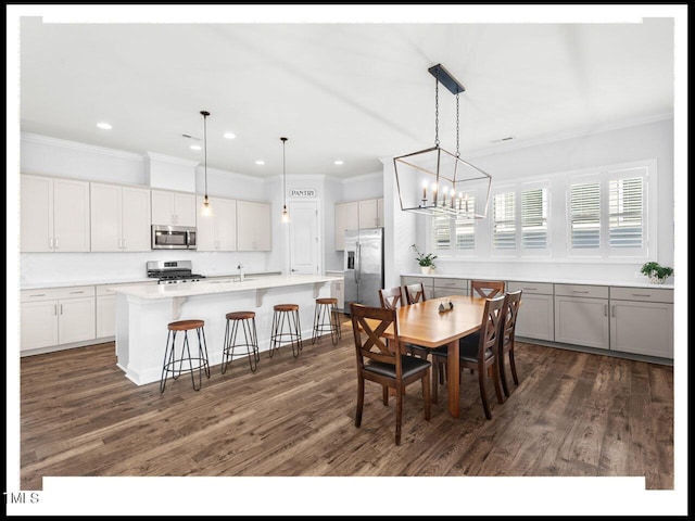 dining room with dark wood-style floors, an inviting chandelier, and ornamental molding