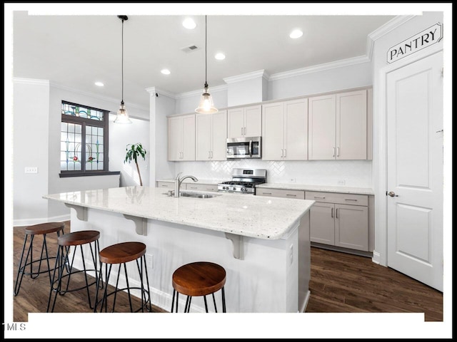 kitchen featuring visible vents, a sink, backsplash, appliances with stainless steel finishes, and dark wood-style flooring